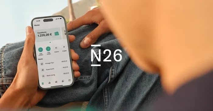 Mann hält Handy mit App am Bildschirm