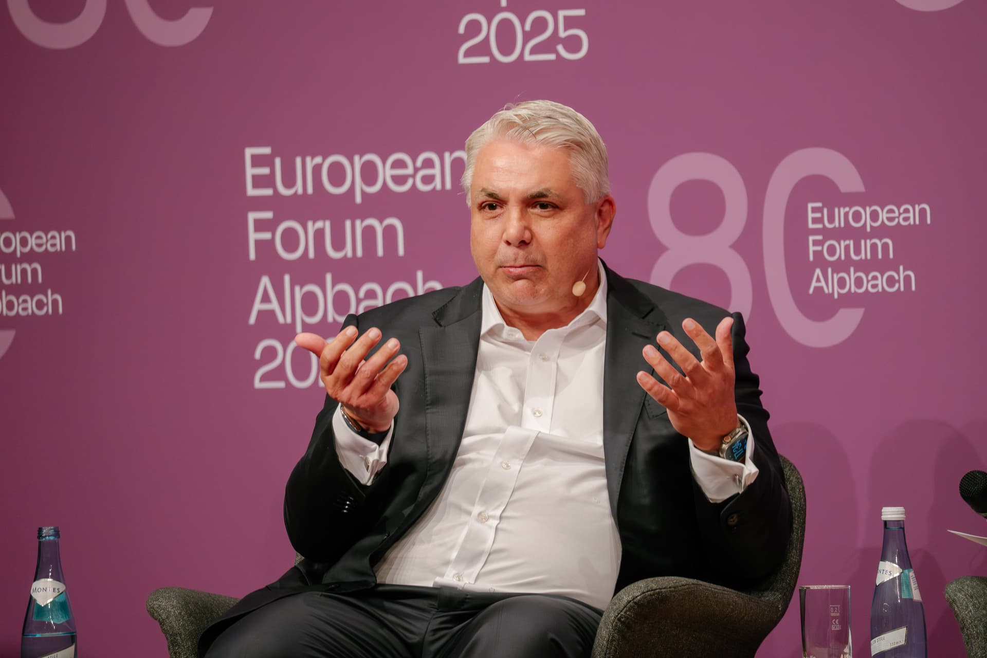 Peter Bosek sitting with both hands in die air at a discussion at Forum Alpbach.